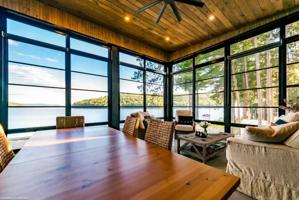 Weather Master window sunroom interior with wooden dining table vaulted wood ceiling and lake views