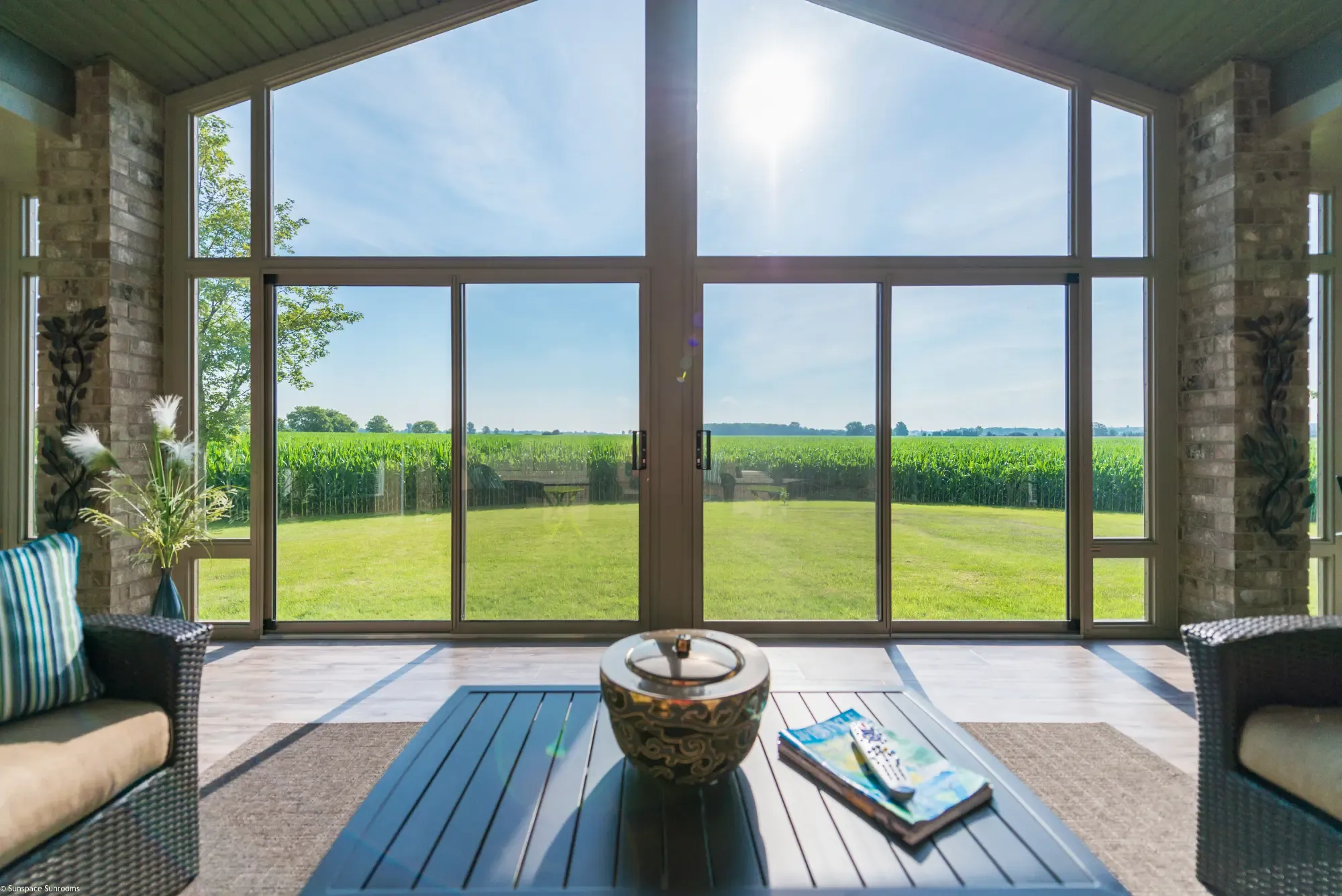Sunspace Model 300 sunroom interior with gabled sliding glass doors looking out over a green field