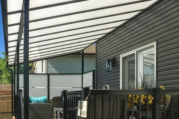 Sunspace LakeField SunWall and patio cover installed over a wooden deck with dark railings