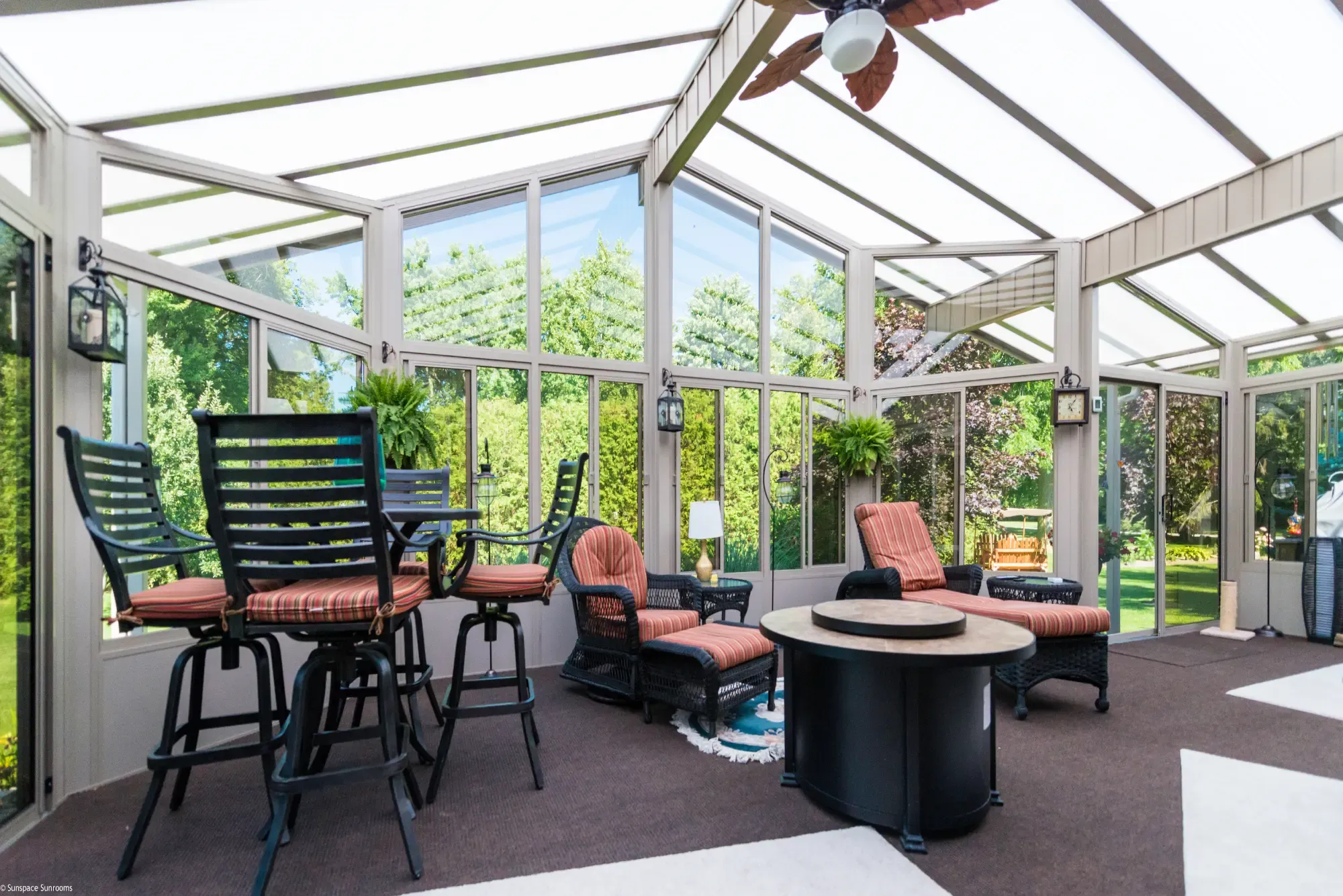 Sunspace Model 300 sunroom interior with translucent roof panels, glass windows, and lounge furniture.