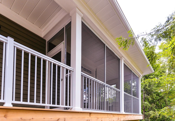 White integrated picket railing system with screen room panels on a wooden deck