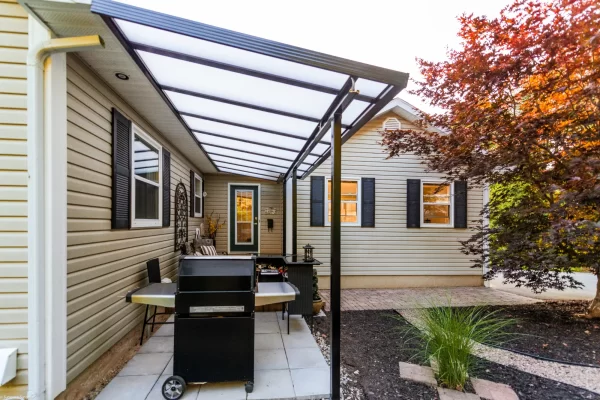 Acrylic Patio cover with translucent roof panels installed over an outdoor paver patio grill area